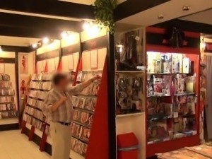 Dude bangs babe in porn store behind front desk