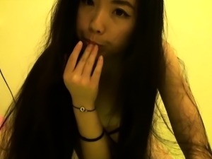 Cute Asian girl enjoys the taste of her peach on her fingers